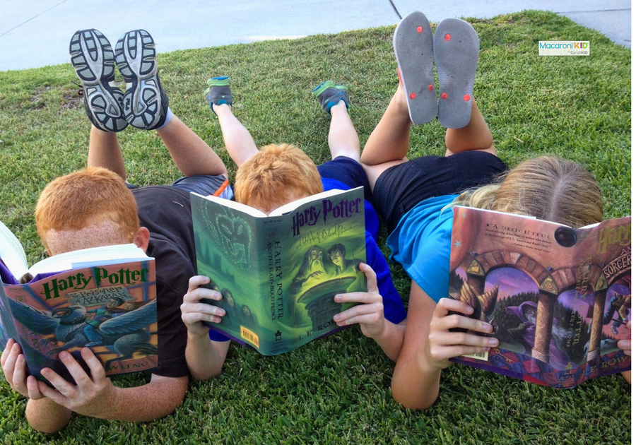 Kids reading outdoors -- summer reading programs for kids to earn free pizza, books and prizes